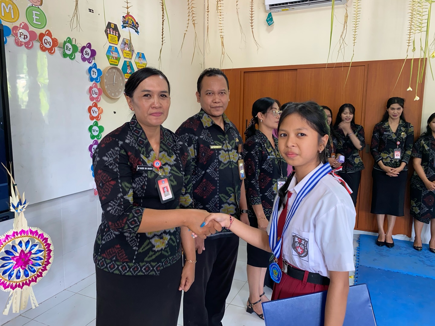 Momen Haru dan Bangga: Kemeriahan Pelepasan Kelas VI dan Pentas Seni SD No. 4 Sading kepala sekolah menyalami murid yang lulus